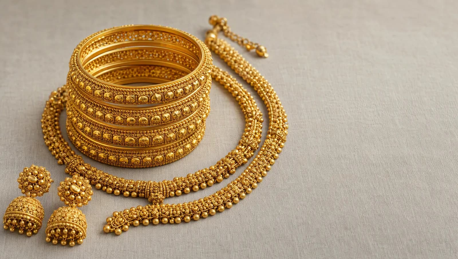22 carat gold jewellery: patterned bangles, a heavy chain and jhumka earrings